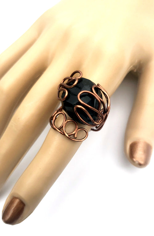 Antiqued copper black spinel statement ring shown on hand with adjustable sculptural wire design