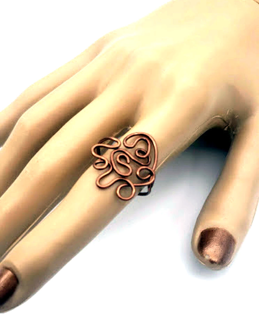 Antiqued copper statement ring with artistic wirework shown worn on hand