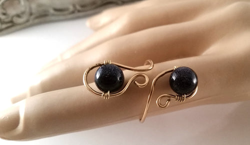 Blue Goldstone adjustable brass ring shown styled on a hand