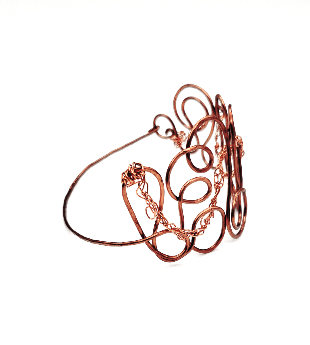 Handcrafted copper statement bangle displaying flowing wire loops, textured details, and sculptural design