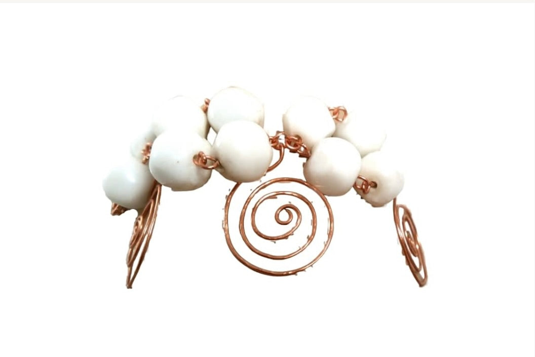 Sculptural copper and ceramic bracelet showing white ceramic beads, copper spiral accents, and handcrafted swirl clasp