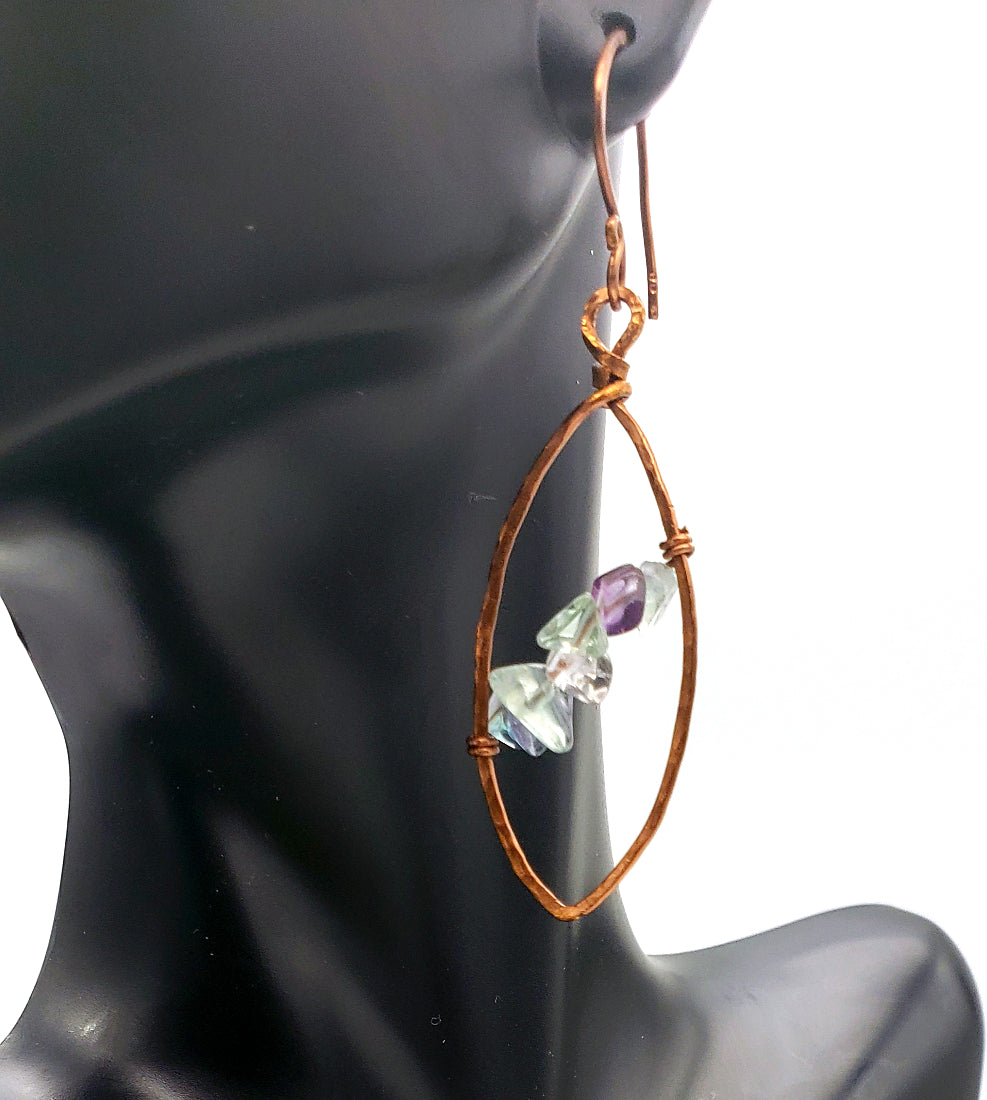 Worn view of fluorite leaf earrings set in antiqued copper wire.