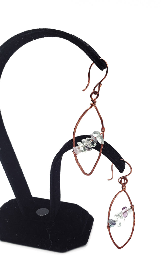 Dangling view of  fluorite leaf earrings set in antiqued copper wire.