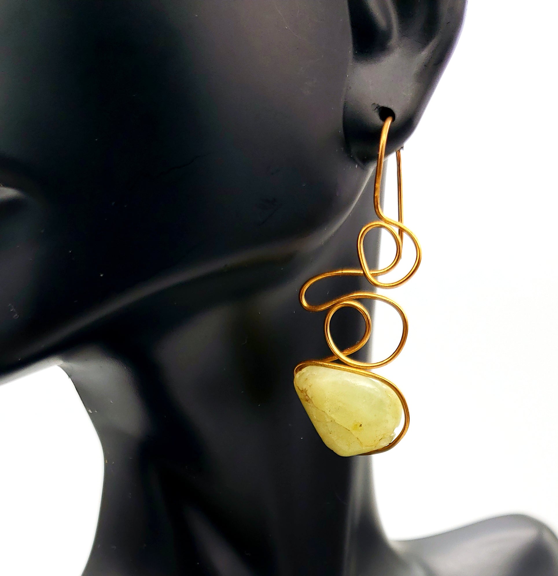 Worn View of Green Garnet Earrings handcrafted in bronze, featuring flowing asymmetrical wirework and natural gemstone beauty.