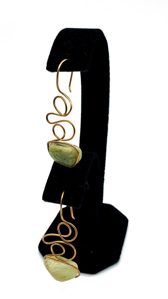 Dangling view of Green Garnet Earrings handcrafted in bronze, featuring flowing asymmetrical wirework and natural gemstone beauty.