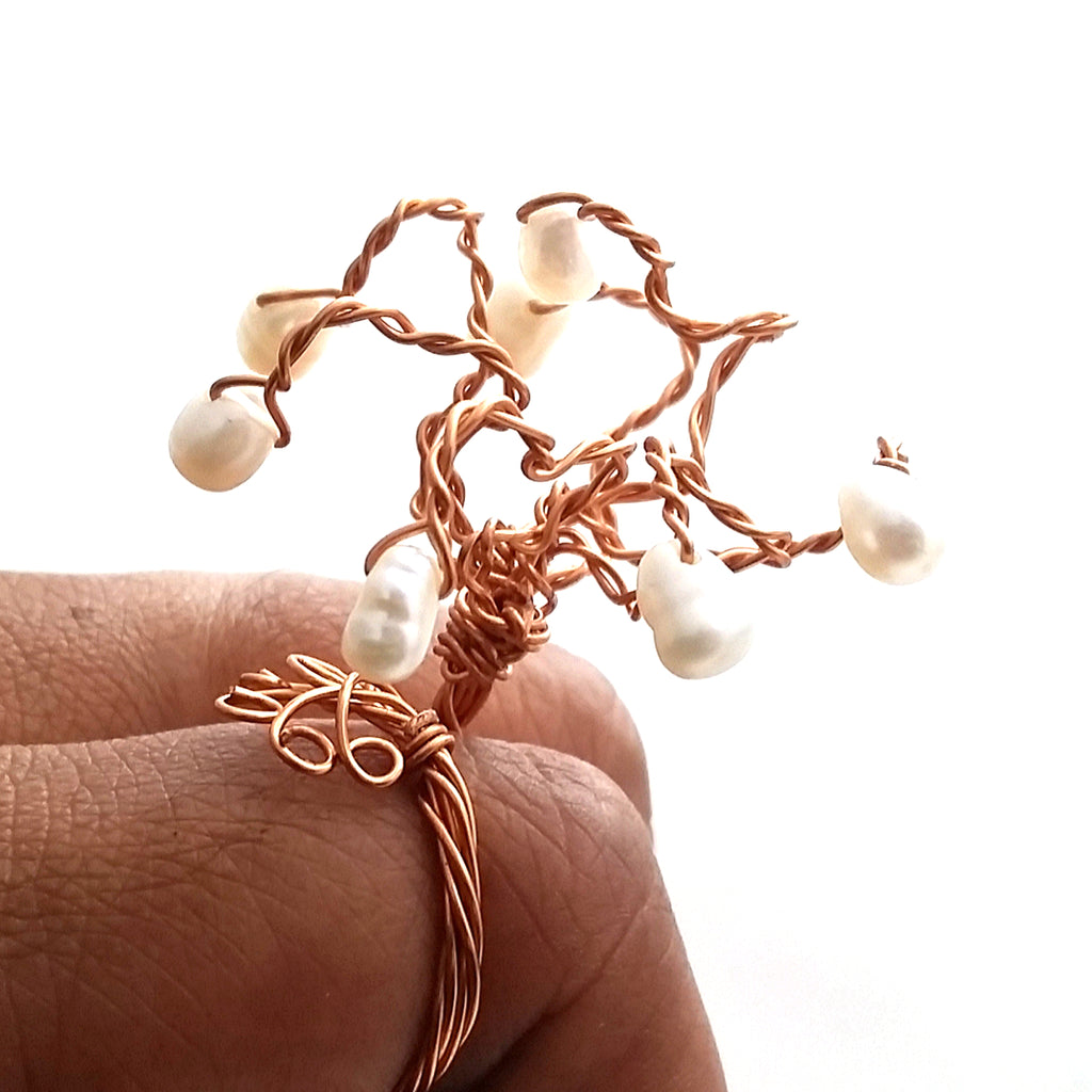 Rooted Tree of Life Ring shown in hand, highlighting sculptural copper branches and freshwater pearls