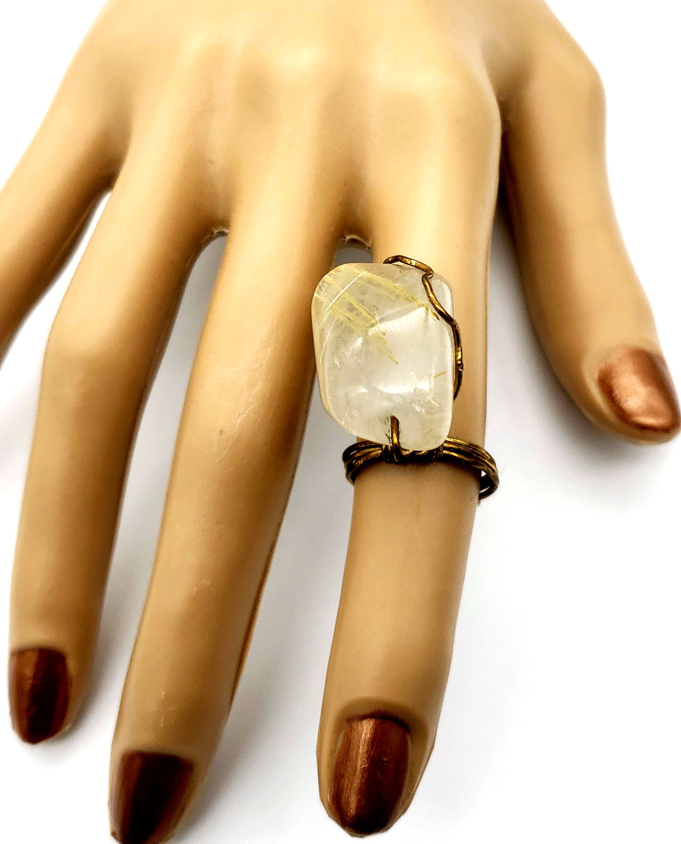 Golden Veil rutilated quartz statement ring shown on hand, featuring a natural quartz gemstone and antiqued brass band
