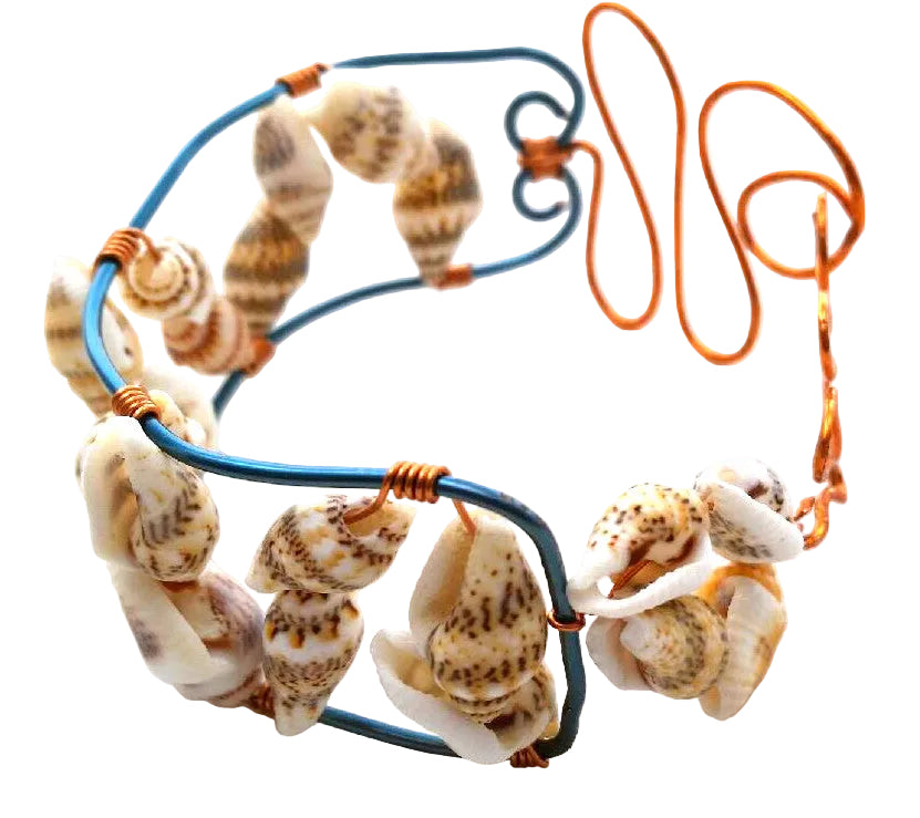 Handcrafted copper and natural shell bracelet showing sculptural waves and blue wire detailing