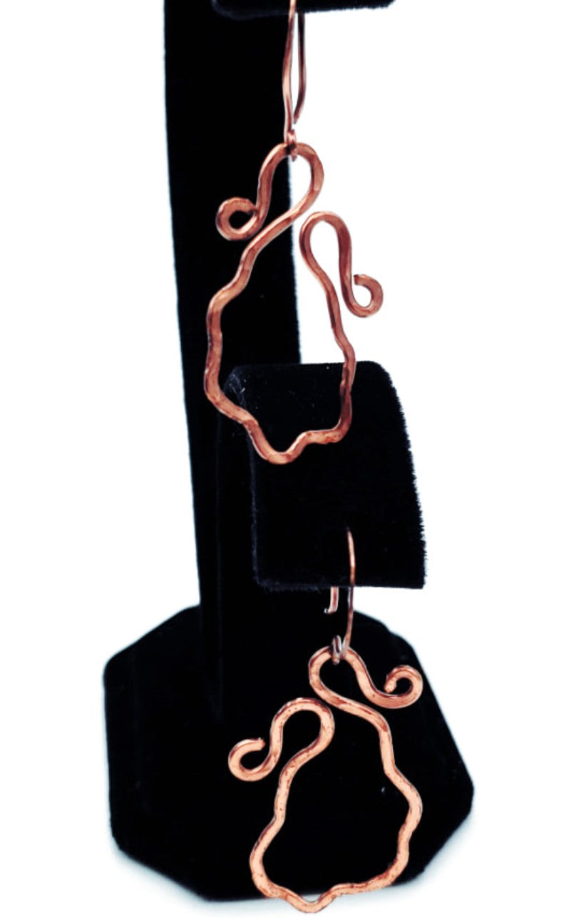Dangling view of Wavy Antiqued Copper Earrings, handcrafted with an organic sculptural design and warm antiqued finish.
